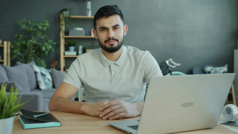 A small business owner working on a laptop at an office desk
