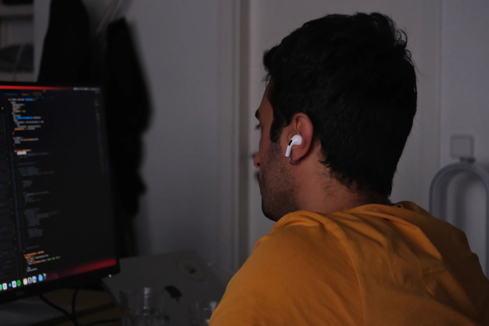 A man working at a computer with code on the screen