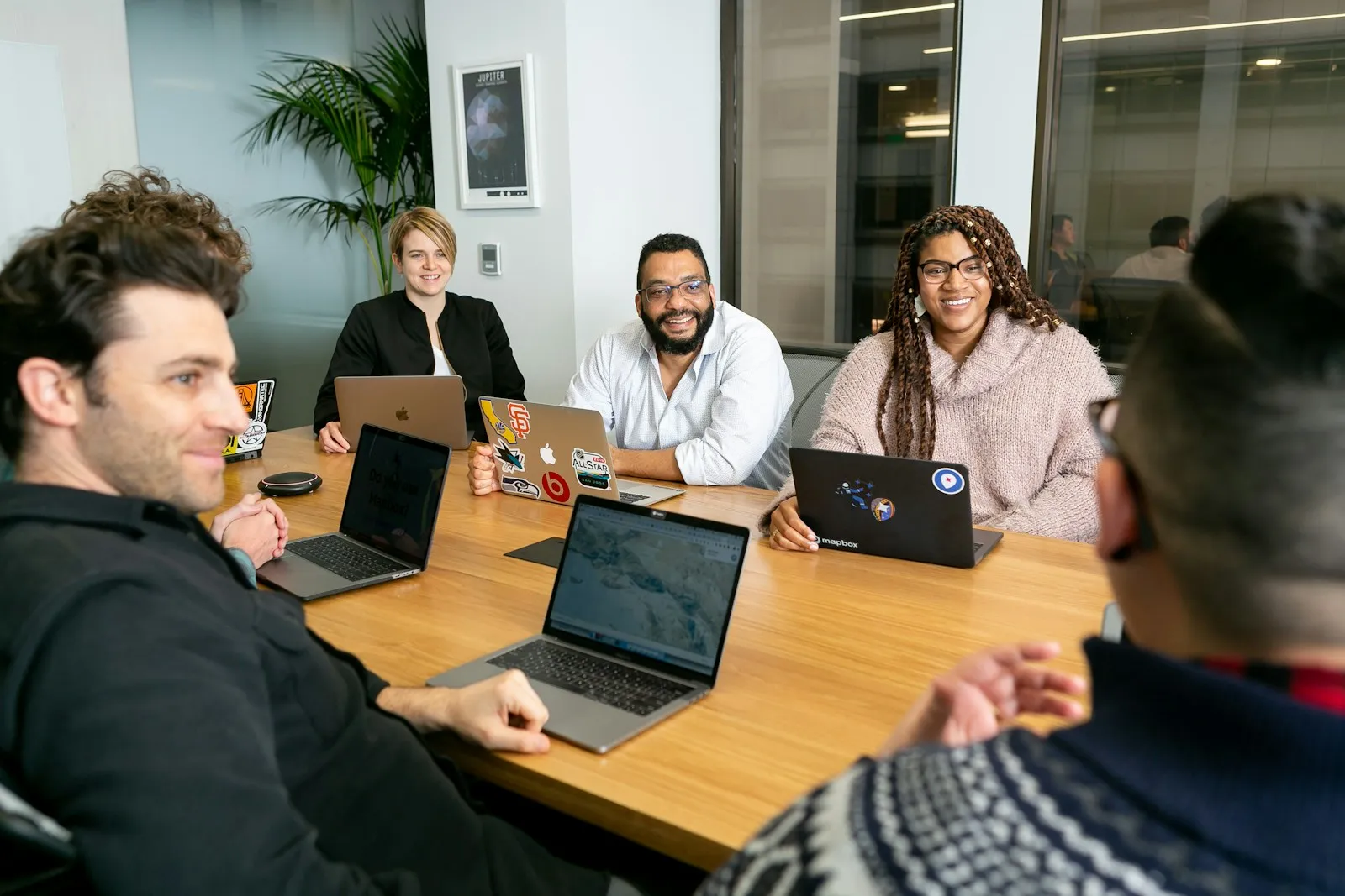 Small business employees working together at laptops in a bright office