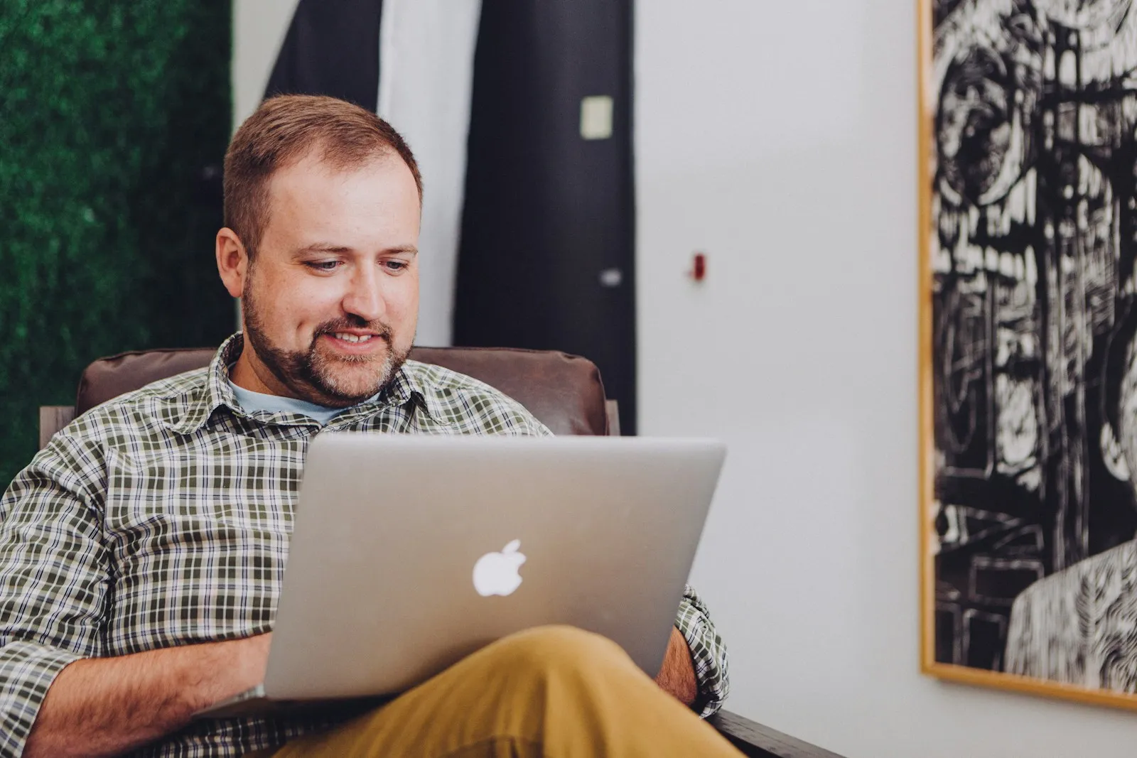 A business owner at a desk typing a question into an AI assistant on a laptop
