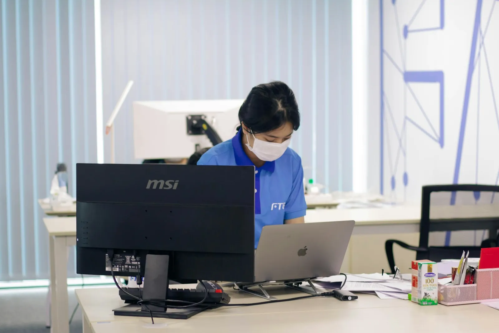Woman working at an office desk with computers
