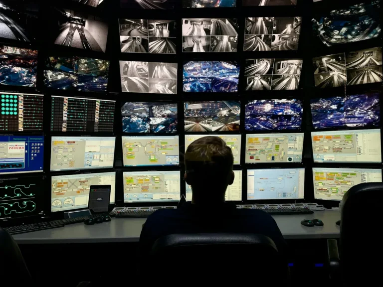 Security analyst looking at monitoring dashboards on several computer screens
