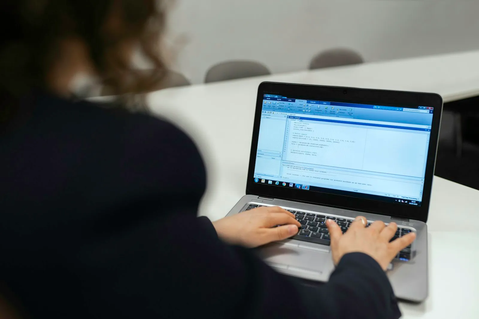 Person using a laptop at an office desk