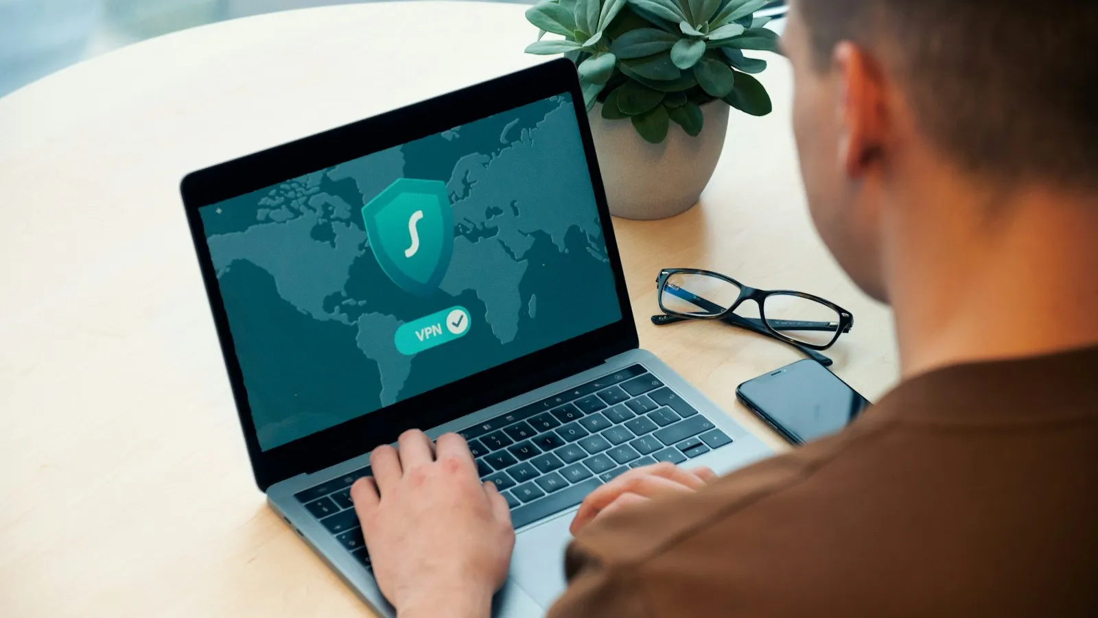 Employee signing in to a laptop with a phone nearby for multi-factor authentication