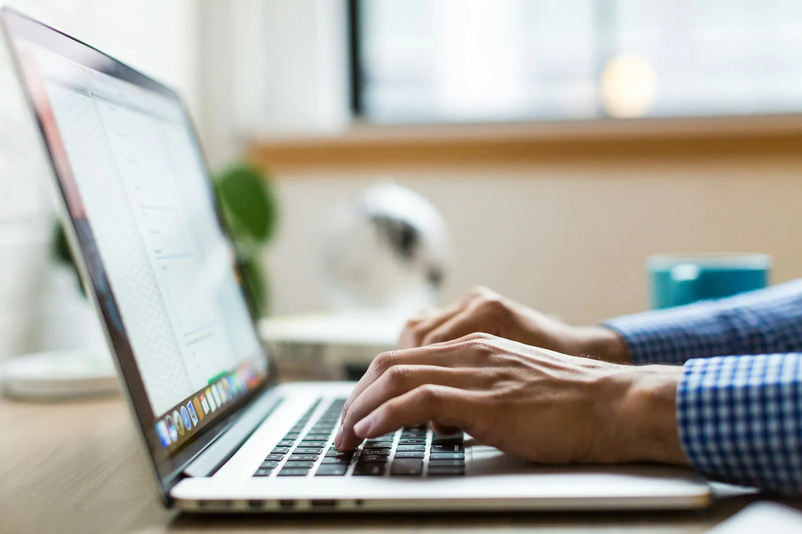 An office worker at a desk using Outlook on a laptop