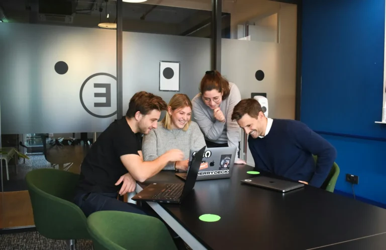 A small business owner and an IT technician reviewing a laptop together at a desk