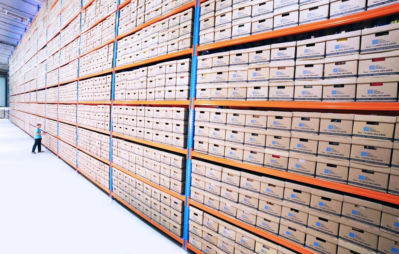 Labeled archive boxes and binders on office shelving