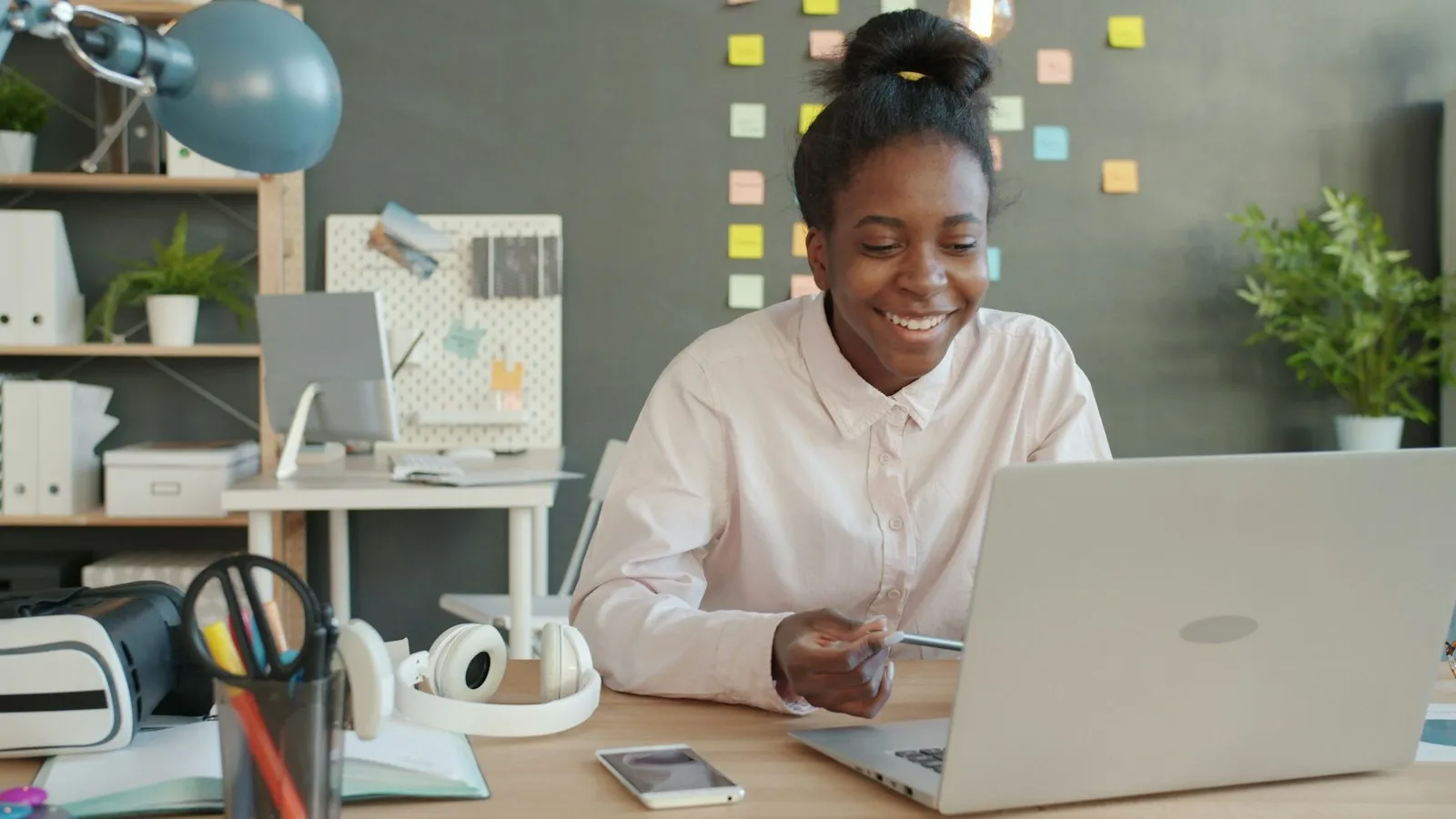 Employee smiling while working on a laptop at a desk