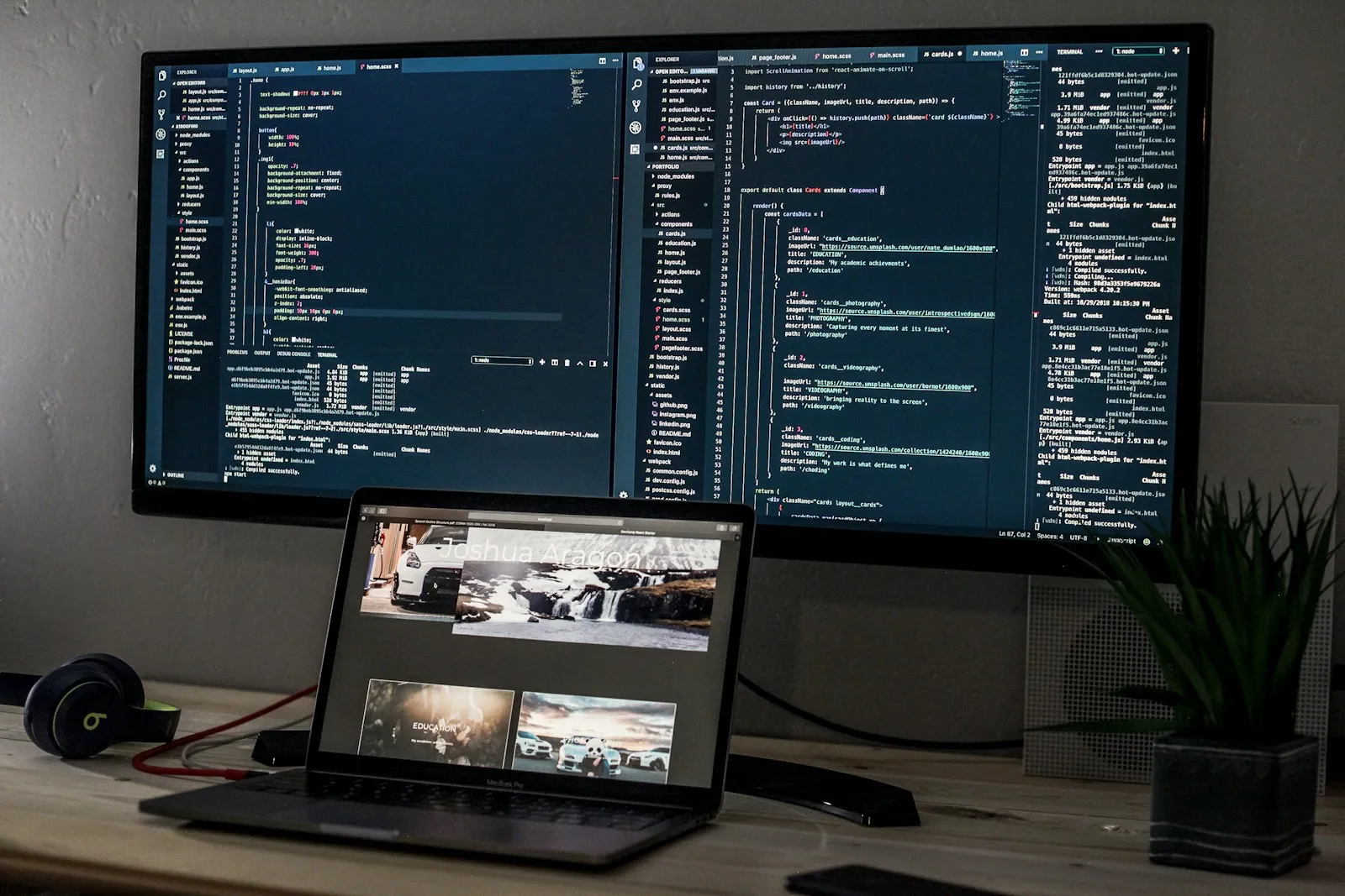 Monitor and laptop showing code on a desk