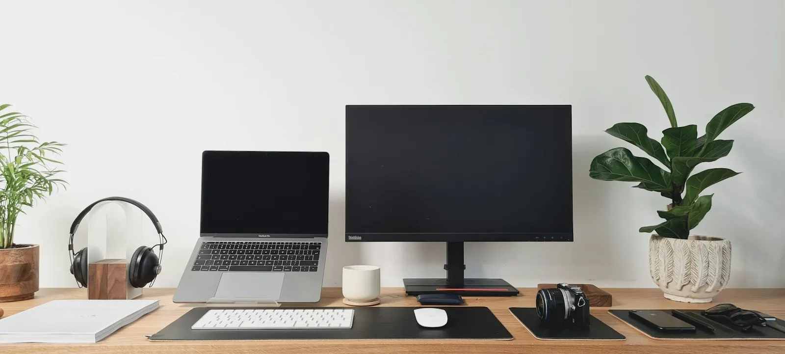 An IT technician setting up a row of new business laptops on a desk