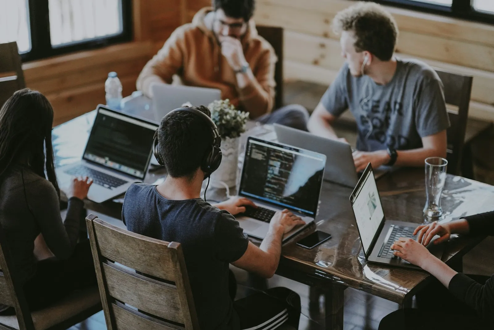 Small office team working together at laptops around a table