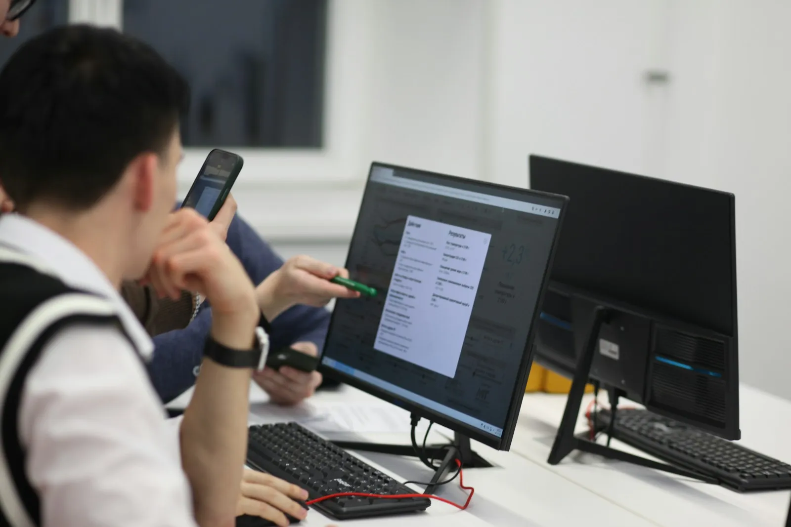 IT staff member working at a desk with two monitors