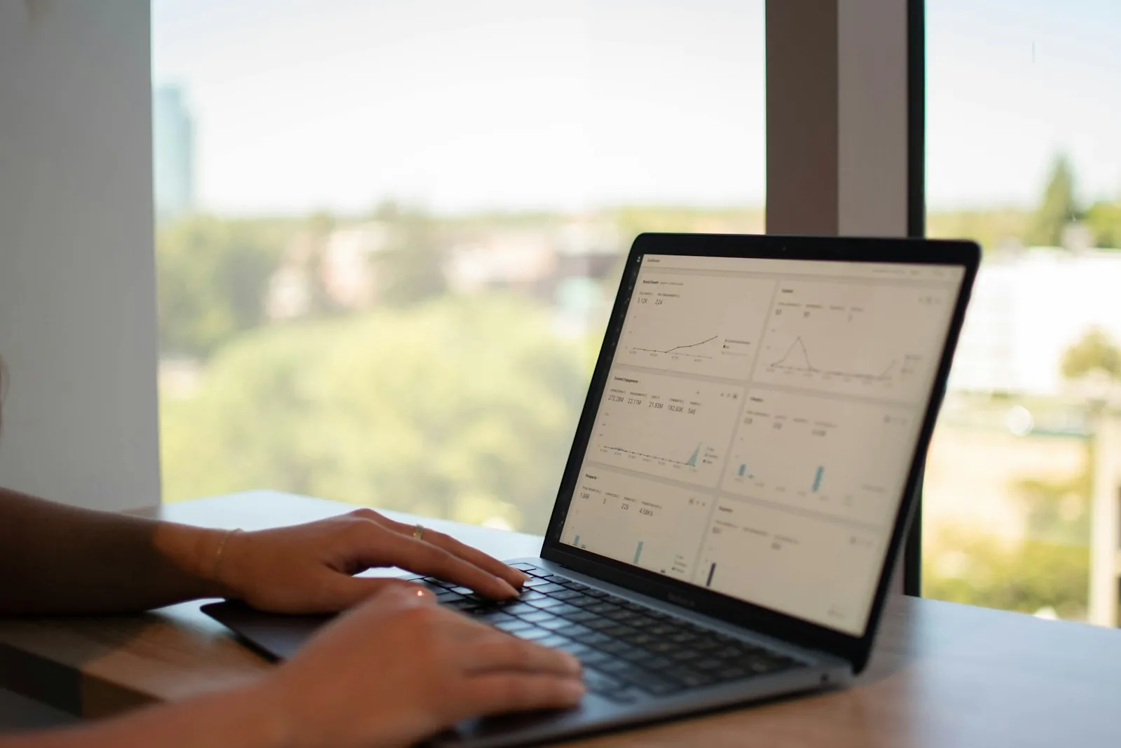 Laptop showing a data dashboard by an office window