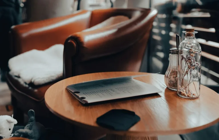 Smartphone left unattended on a cafe table next to a coffee cup