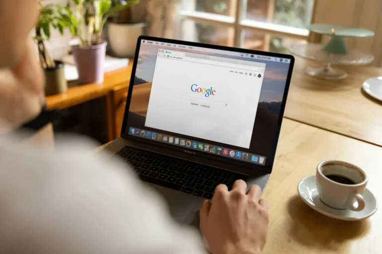 Person's hands on a laptop keyboard with a web browser open on the screen