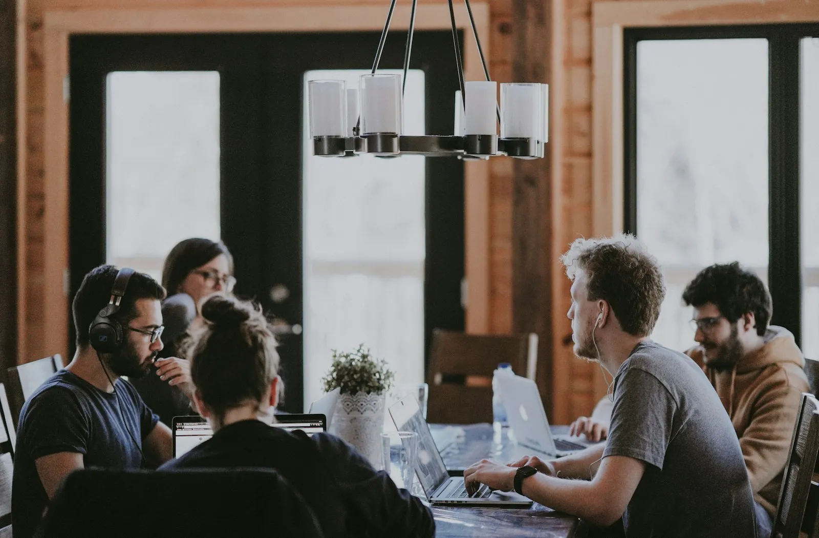 Team meeting around a conference table with laptops