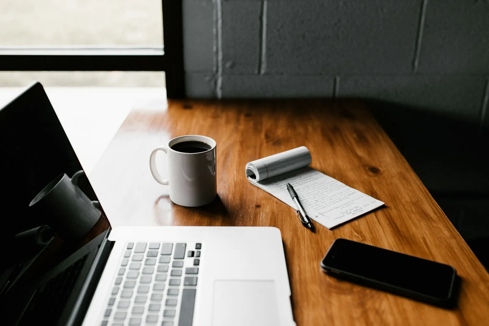 A small business employee working on a document on a laptop at a desk