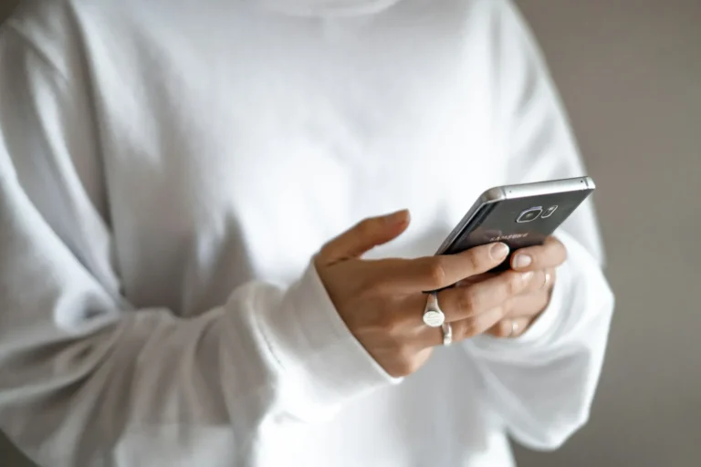 A person holding a smartphone and reading a text message
