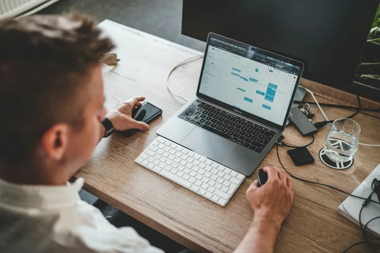 A new employee unboxing and signing in to a laptop at an office desk