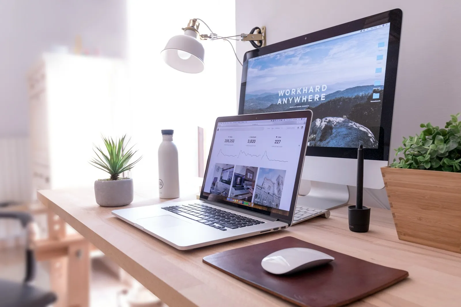 Desk with a laptop and monitor set up in a bright office