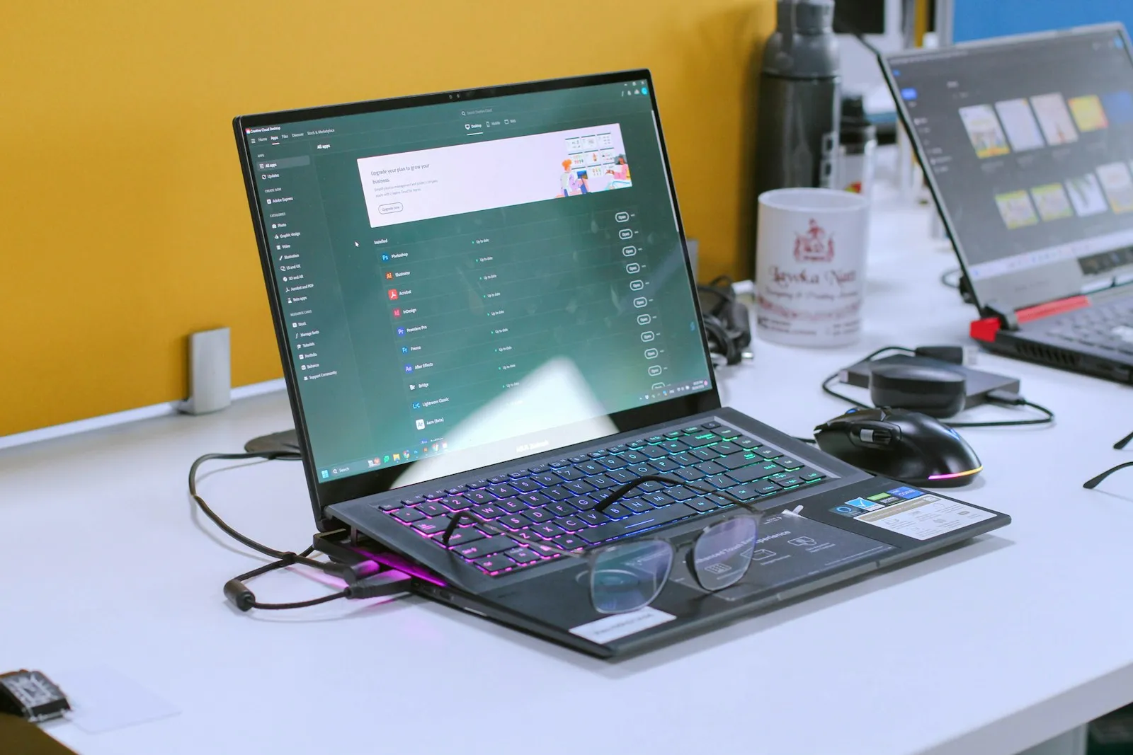 A business owner and an accountant reviewing equipment invoices at a desk with a laptop