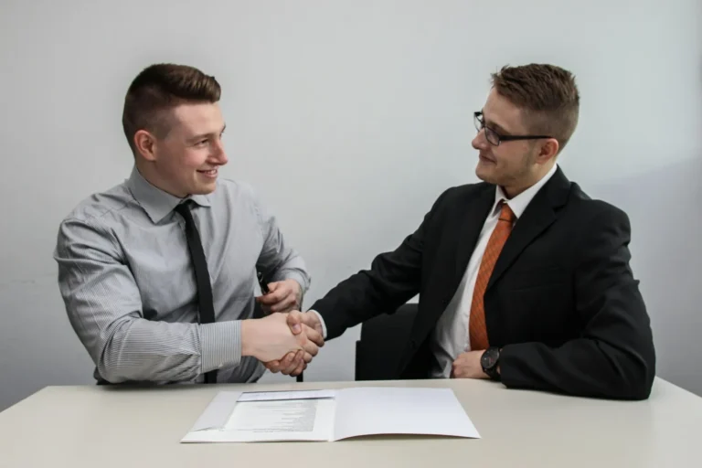 Two people reviewing a printed contract at an office table