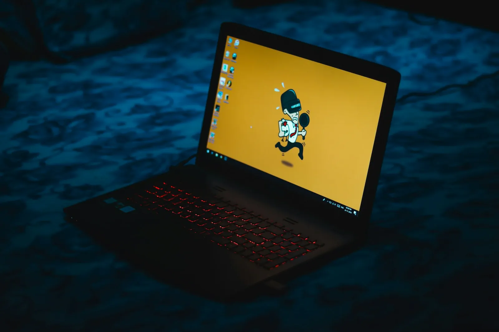 Laptop with a warning graphic on its screen in a dark room
