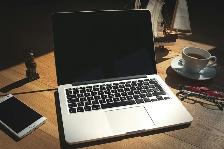 IT technician setting up new laptops on a desk in a small office