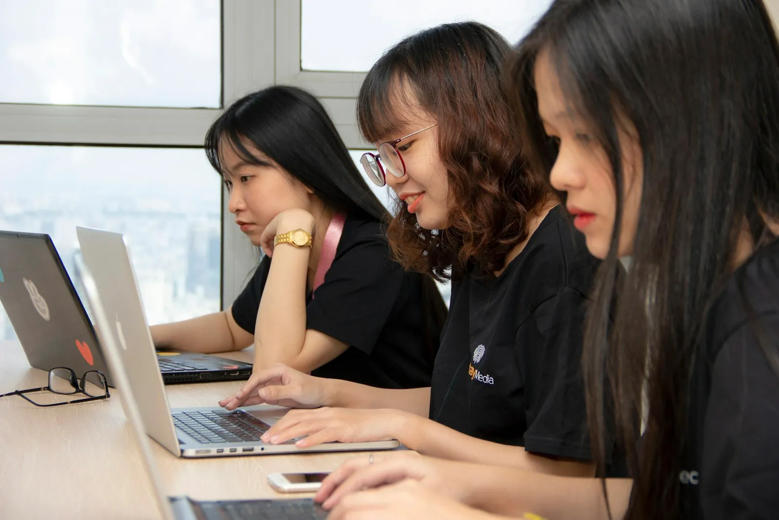 Volunteers working together at a table with laptops at a community nonprofit