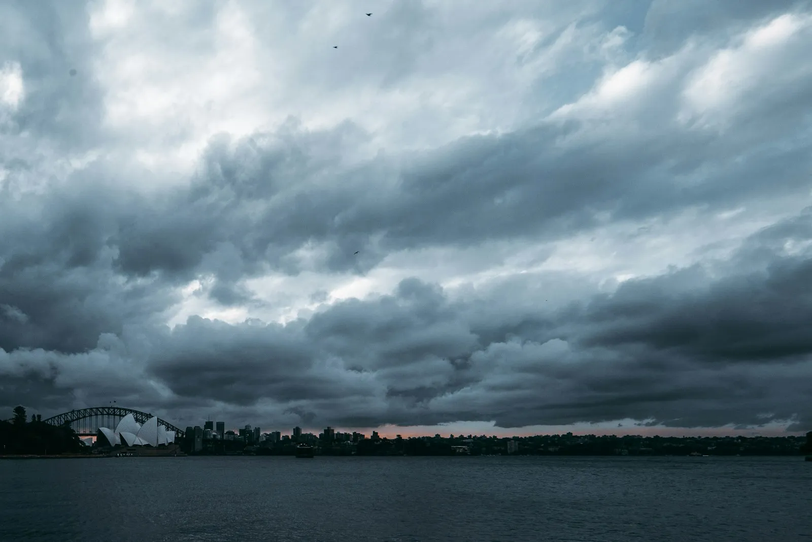 Dark storm clouds over a city skyline, suggesting an approaching hurricane