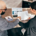 A business owner comparing two printed IT service proposals at a desk