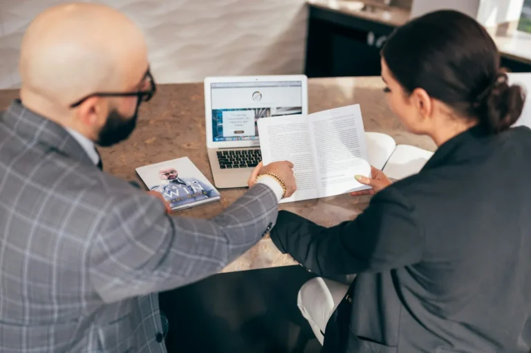 A business owner comparing two printed IT service proposals at a desk