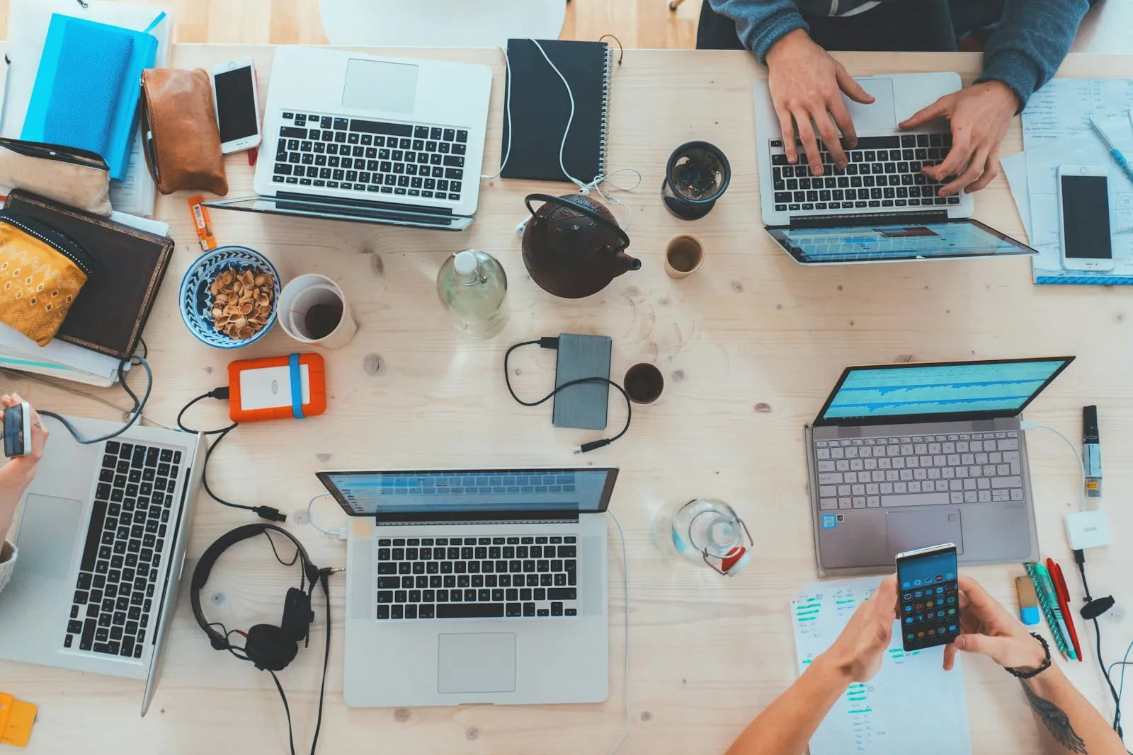 Overhead view of a team working on laptops at a shared table